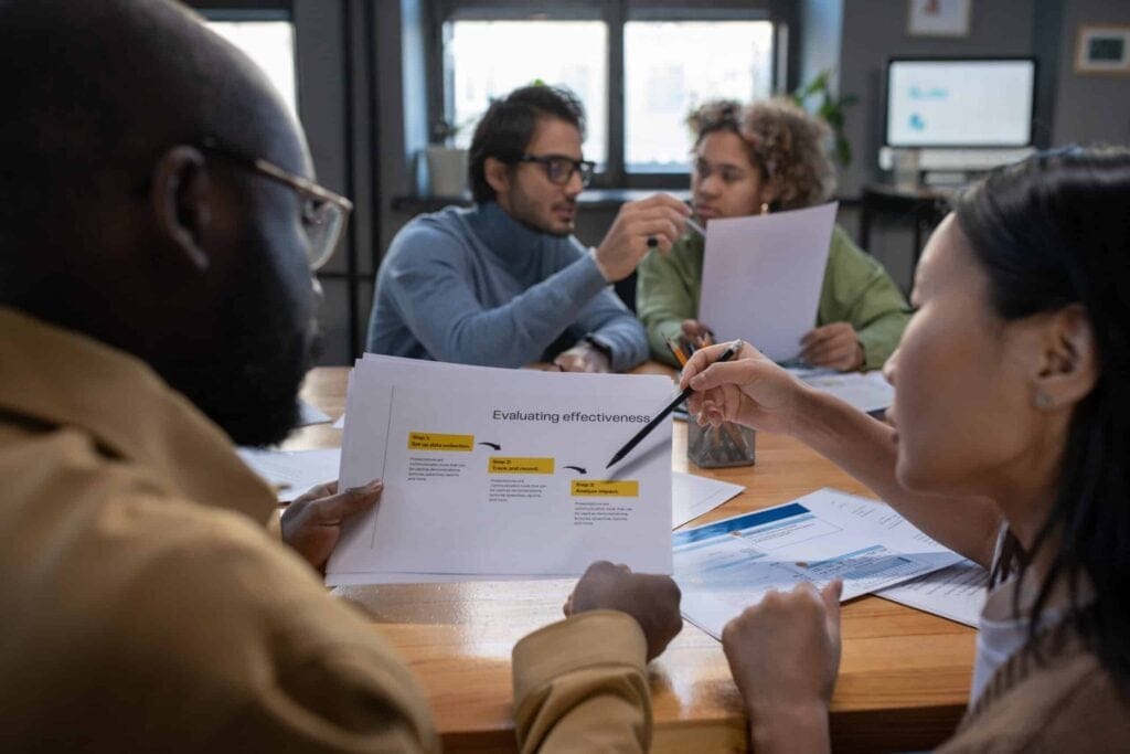 Colleagues discussing effectiveness and continuous improvement strategies during a meeting.