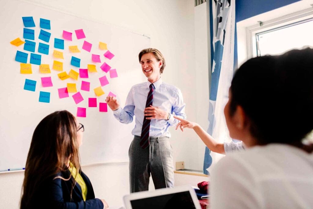 Business team collaborating with sticky notes on a whiteboard during a meeting.