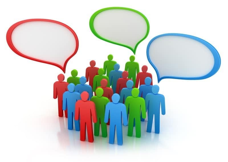 Colorful speech bubbles above a diverse group of people discussing ideas and communication.