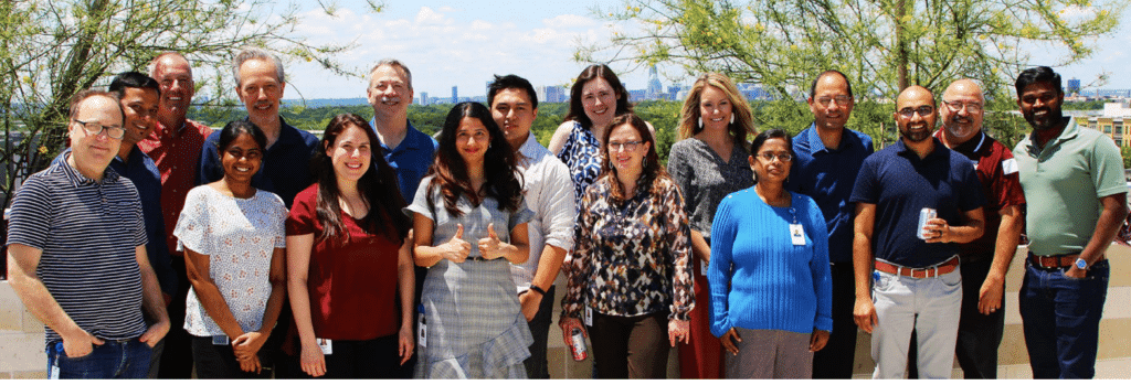 Team celebration group photo in the sun, showcasing smiles and camaraderie.