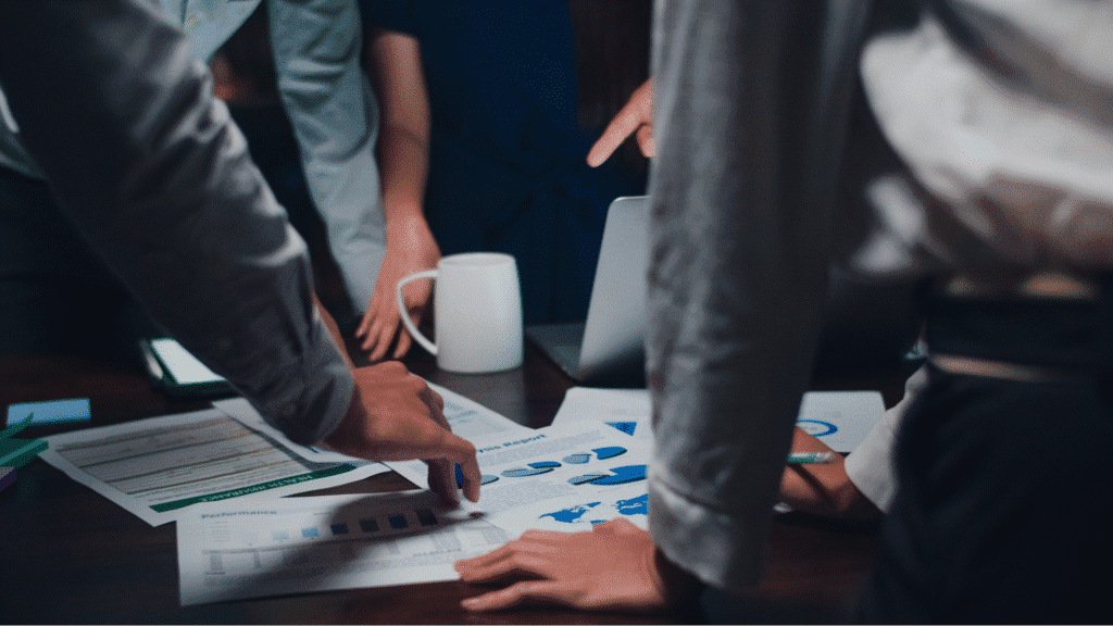 Team collaborating on data analysis, reviewing charts and strategies in a meeting.