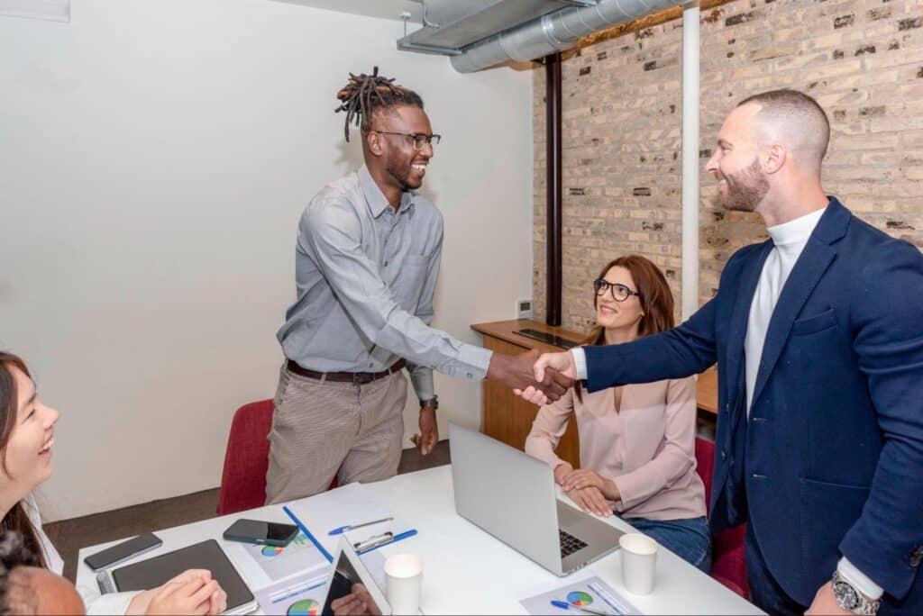 Business professionals shaking hands in a modern meeting room during a successful collaboration.