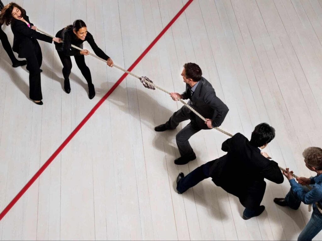 Competitive teamwork during a tug of war challenge in a corporate setting.